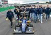 MoRe Modena Racing team members walking behind their car on the pit straight of Silverstone circuit